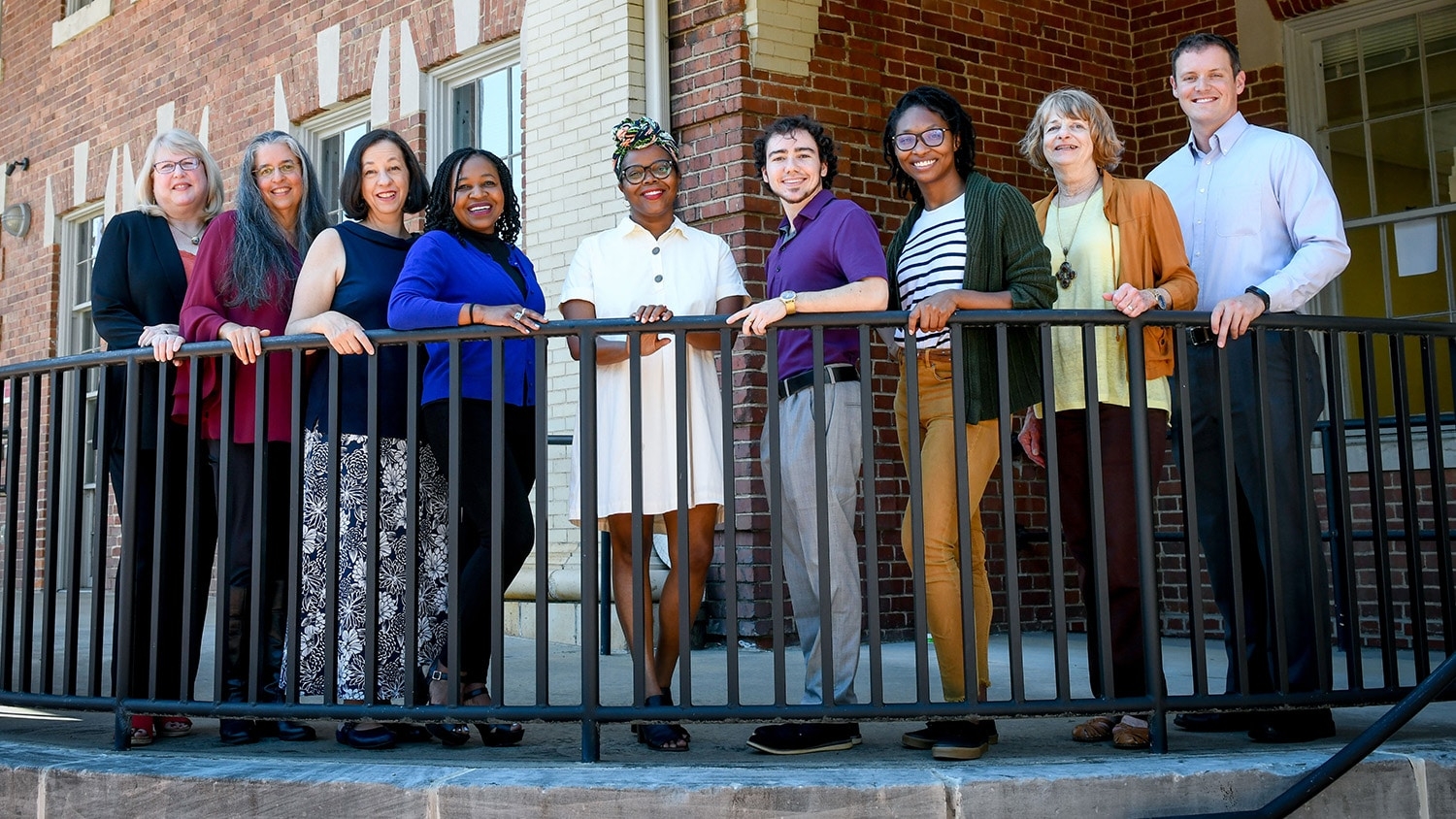 Group of faculty standing in front of School of Social Work building.